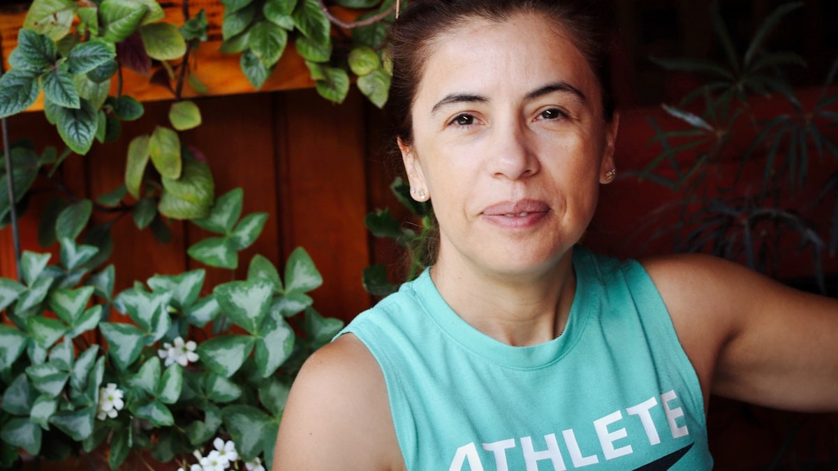 Woman in a teal tank top with plants